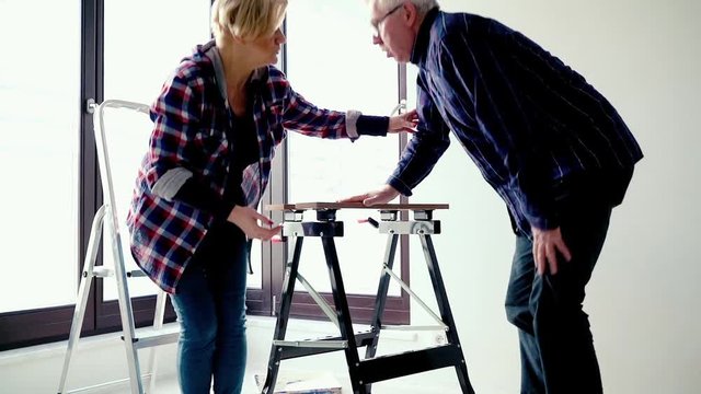 Mature man having backbon pain during assembling furniture at their new home
