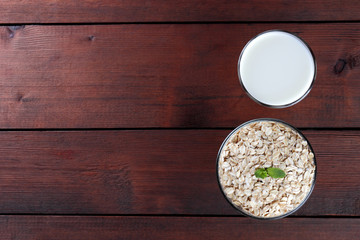 Oatmeal, milk and mint. Oat flakes on wooden boards. Milk and oatmeal for breakfast. Healthy food....
