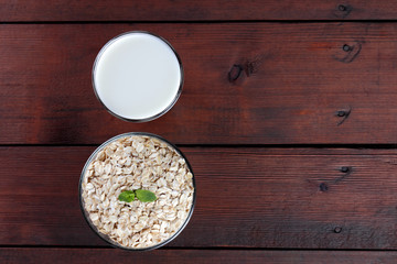 Oatmeal, milk and mint. Oat flakes on wooden boards. Milk and oatmeal for breakfast. Healthy food....