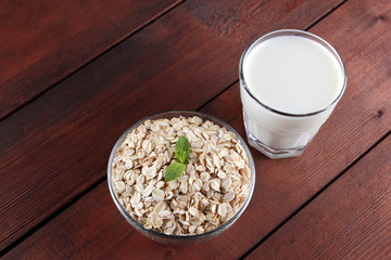 Oatmeal, milk and mint. Oat flakes on wooden boards. Milk and oatmeal for breakfast. Healthy food....