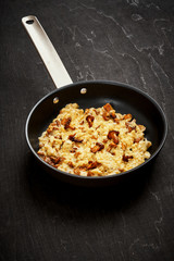 delicious scrambled eggs with chanterelles straight from the forest in a pan on a wooden kitchen table
