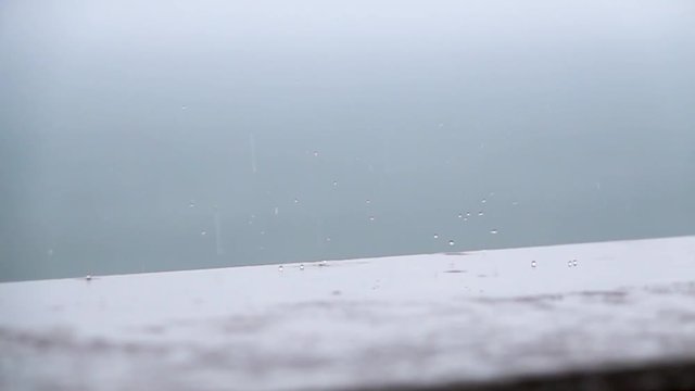 Rain drops beating against the sill in slow motion