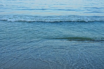 blue sea waves with white foam on the beach