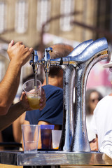 Fototapeta na wymiar barman serving draft beer pouring in street fest