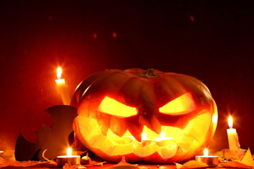 Halloween. Bat. Halloween pumpkin head jack lantern on wooden background. Autumn leaves and candles