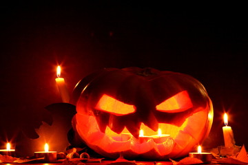Halloween. Bat. Halloween pumpkin head jack lantern on wooden background. Autumn leaves and candles