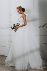 beautiful sexy blonde bride. posing in wedding dress in white room