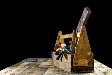 Box with accessories for the carpenter. Carpentry tools in a crate on a wooden workshop table.