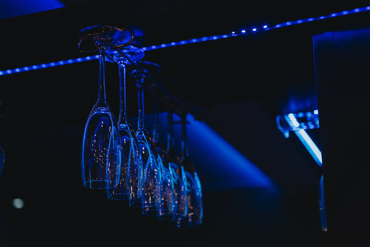 Low angle view of champagne glasses hanging on a glass hanger in a bar
