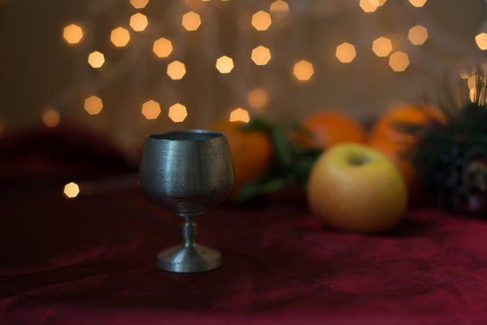 Metal cup, candle and fruit still life
