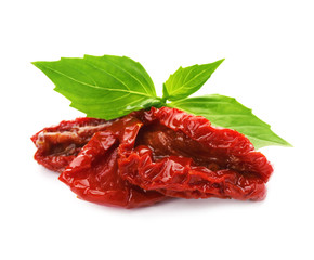 Tasty sun dried tomatoes with green leaves on white background