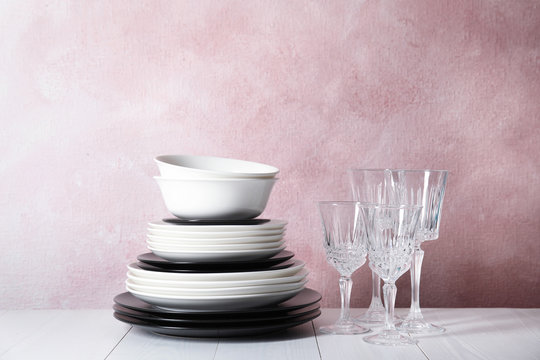 Set of dinnerware on table against color background. Interior element
