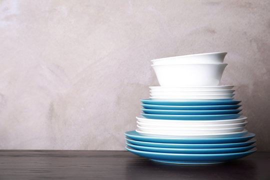 Set of dinnerware on table against grey background with space for text. Interior element