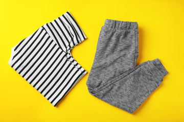 Flat lay composition with cute child clothes on color background