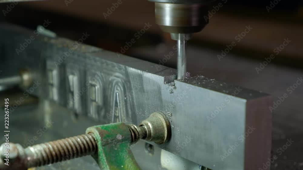 Poster automated cnc control numeric router cutting a piece of aluminum leaving shaving side view close up