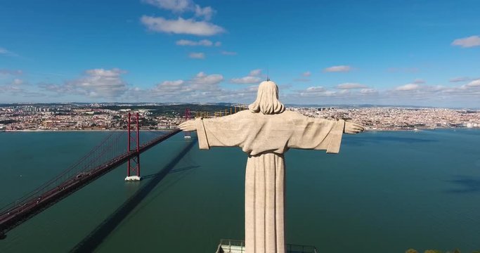 Drone shot of Christ the King Sancturary and Ponte 25 de Abril bridge in Lisbon, 25 of April Bridge, Portugal