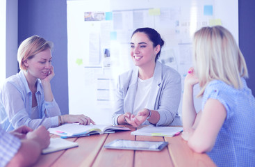 Fototapeta premium Young people studying with books on desk. Beautiful women and men working together.