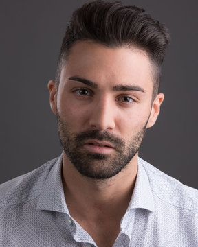 Headshot of man with stuble and grey background