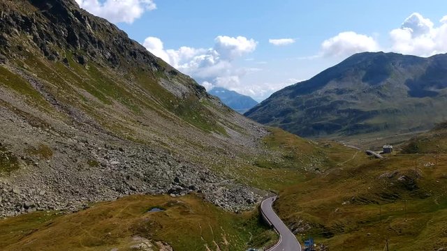 The camera climbs and pans right over the summit of the Spl&uuml;gen pass in Switzerland and slowly gives the viewer a glimpse through the Alpine valley and into Italy in the distance.