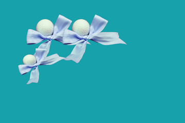 Golf ball with blue ribbon on blue background idea for boy baby shower for golfer