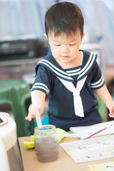 Little baby boy drawing picture water coloring