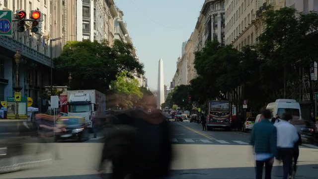 People crossing, public transport and Obelisk of Buenos Aires at daytime wide shot timelapse zoom in
