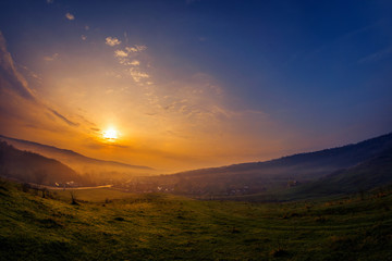 Beautiful sunrise in the countryside with fog over the village