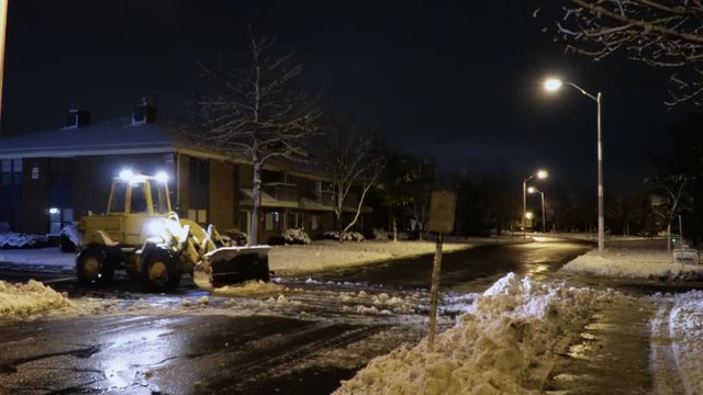 Tractor snow cleaning at nightthe street after snowfall