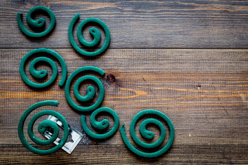 Mosquito repellent for outdoor: garden, summer house, picnic. Green spiral on dark wooden...