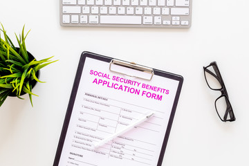 Social security benefits. Application form near pen and glasses on white background top view
