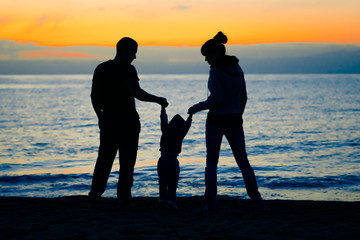 family at sunset by the sea