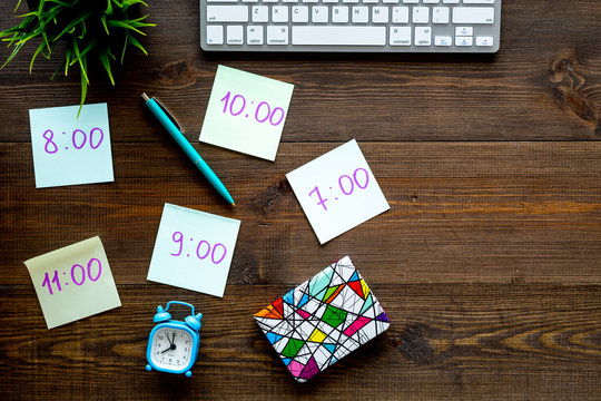 Student's schedule. Notepaper with time of lessons on dark wooden office desk with computer keyboard top view copy space