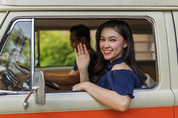 happy woman vintage window of old car and raising her hand
