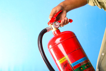 A man holding fire extinguisher on blue background.