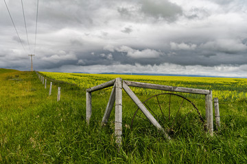 Old fence and field against a dramatic sky in southern Alberta, Canada