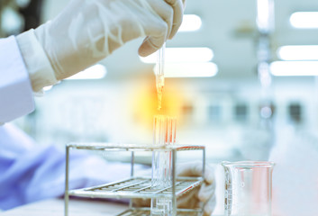 Scientist  using the dropping liquid in to the Science experiment tube.