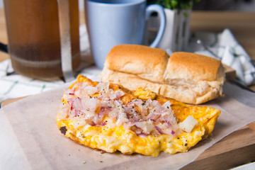 cheese omelette topped with onion and garlic with Filipino pandesal