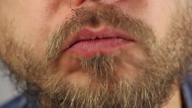 young man bites off a traditional Russian pie with potatoes filling and chews it, closeup macro
