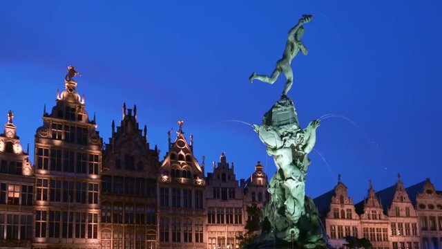 Amazing evening view of guildhalls and Brabo Fountain illuminated by electric light at Grote Markt or Great Market Square, Antwerp, Belgium. Gorgeous landmarks of beautiful old European city at night.