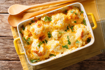 Delicious baked fresh cauliflower with cheese sauce close-up in a baking dish. horizontal top view