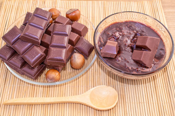 Chocolate slices and hot melted chocolate. Chocolate with hazelnuts. Nuts of hazelnuts.