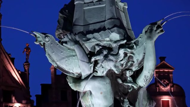 Close-up of bronze decorations of Brabo Fountain depicting scene from Flemish legend. Beautiful details of popular historical landmark illuminated at evening. Great Market Square, Antwerp, Belgium.