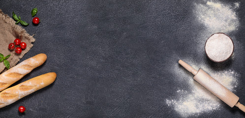 home-made bread and baguette on a gray background with flour