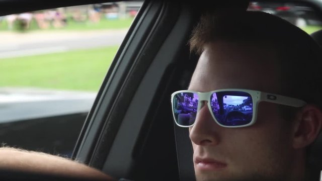 Handsome Male with Sunglasses Driving in Rear View Mirror