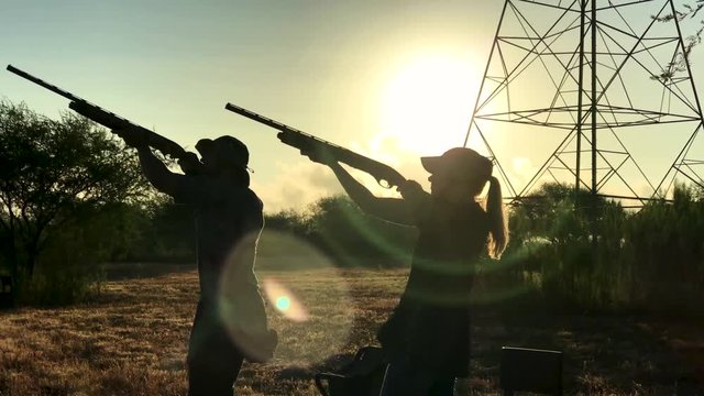 Couple aiming guns to shoot during dove season. Slow motion shot.