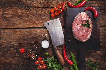 Raw fresh cross cut veal shank and ingredients for Osso Buco cooking on black background