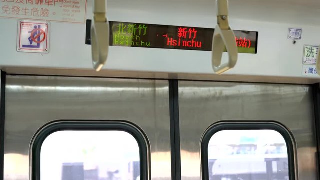 Riding a public train and looking up at the electronic sign in Hsinchu, Taiwan.