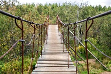 Wooden suspension bridge over the river