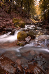 Beautiful mountain waterfall with fast flowing water and rocks, long exposure.