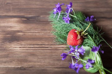 Dill, parsley, strawberry on old wood board